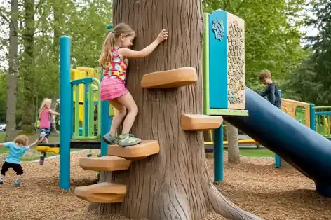 Children climbing a tree-inspired play structure, blending nature with adventure in a vibrant playground setting