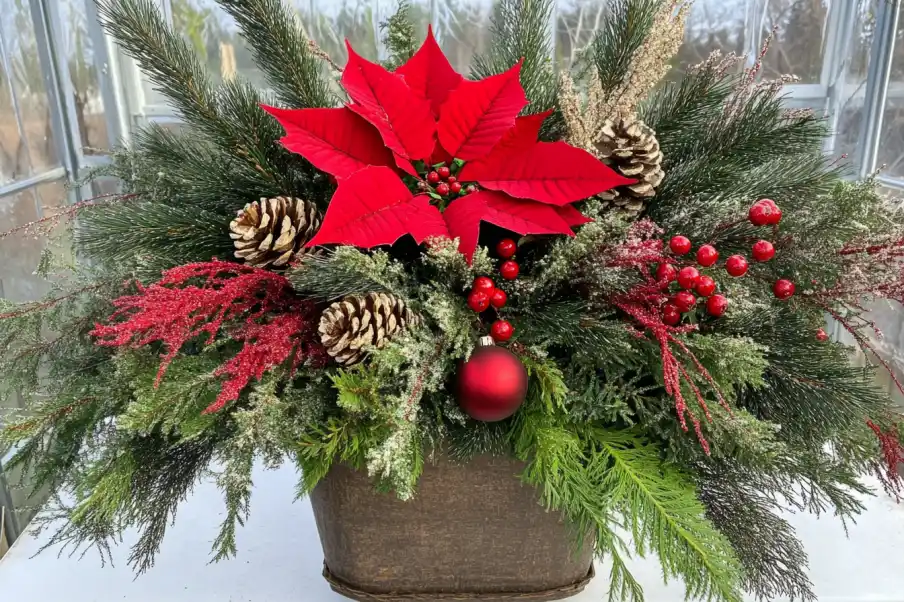 Festive holiday arrangement with evergreen branches, red berries, and a large red poinsettia, perfect for seasonal decor