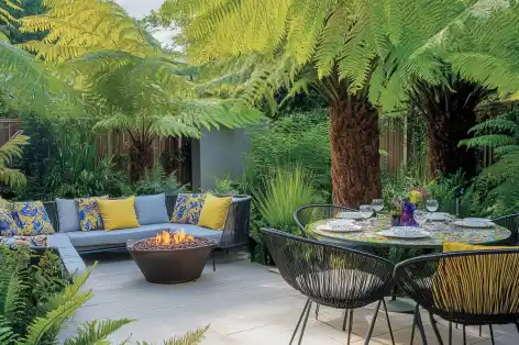 Modern tropical patio with cozy seating, fire pit, and lush ferns