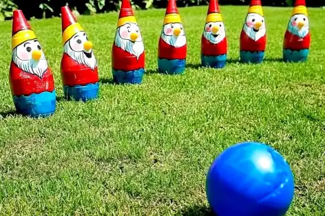 creative outdoor bowling game with colorful, painted bottle pins and a ball. 