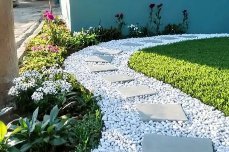 Curved garden pathway with square stepping stones, white pebbles, and vibrant greenery for a clean, modern look