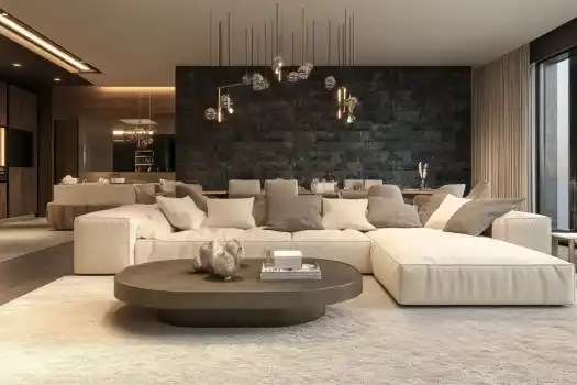 A small living room with a cream sectional sofa, a round coffee table, and modern pendant lights, featuring a cozy, elegant design.